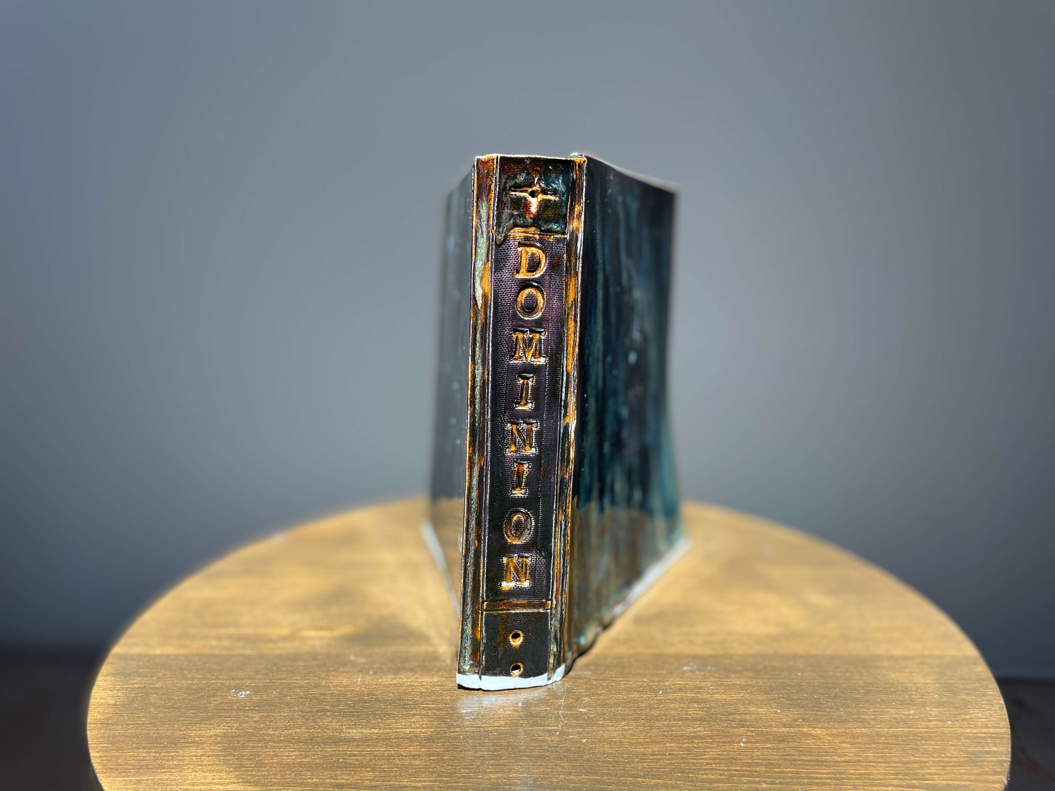 Dan Nuttall's ceramic sculpture of a book titled "Dominion" showing book spine 